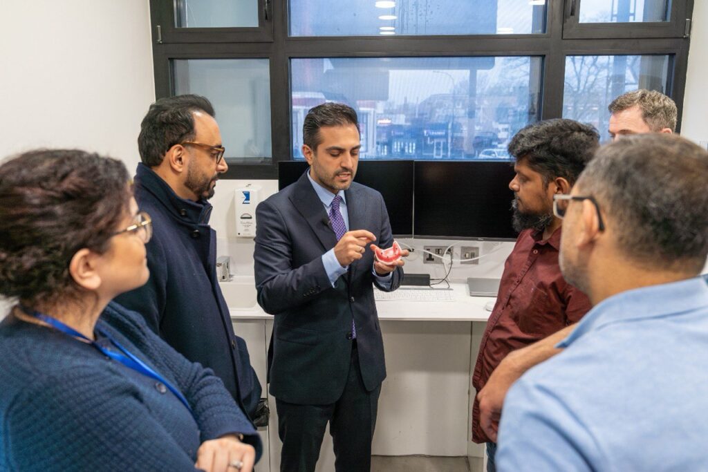 Dr Arman Barfeie explaining dental implant treatment to patients at his London clinic