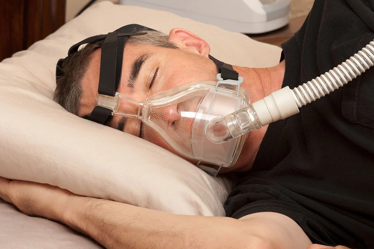 Man sleeping with a CPAP mask for sleep apnoea treatment